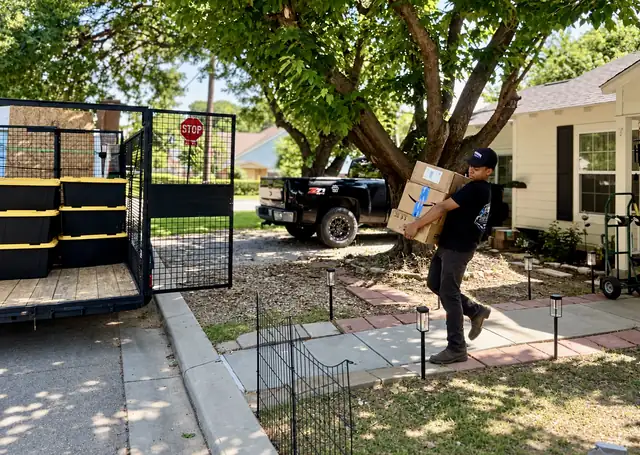 Recourse crew member carrying boxes from a home to the trailer