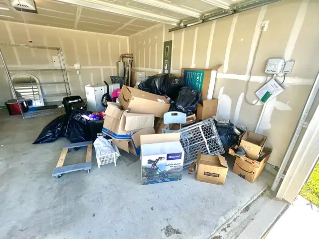 One-car garage filled with boxes and bins before cleanout