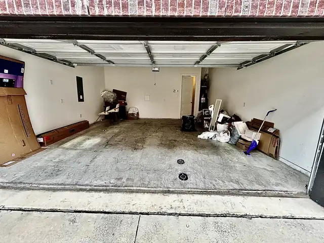 Two-car garage with leftover items before cleanout