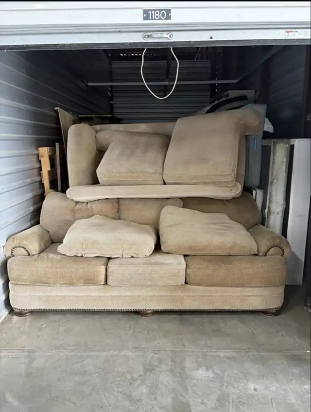 Storage unit filled with a sofa and loveseat before cleanout